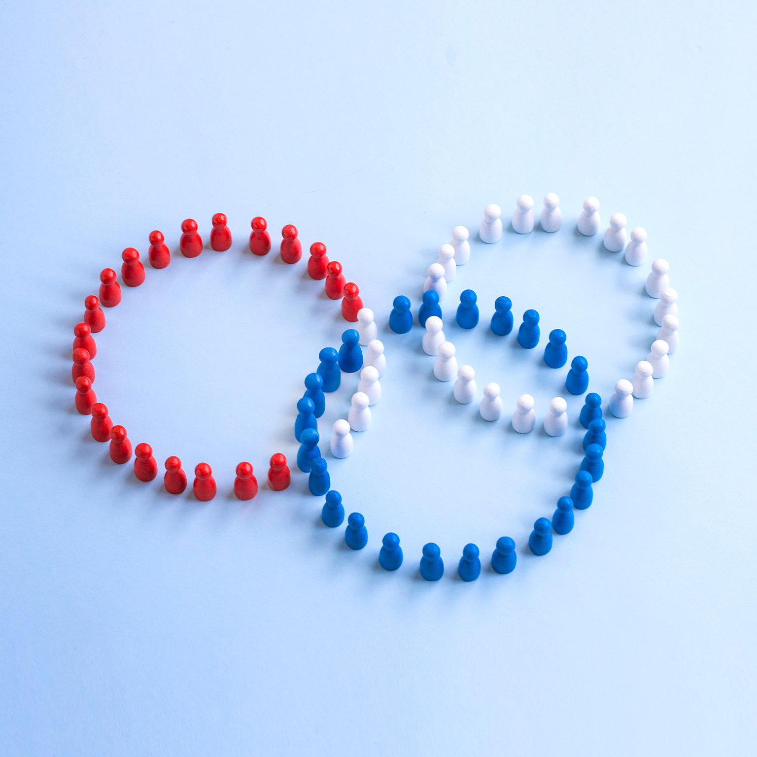 Three coloured rings form by wooden figure overlapping on coloured background.