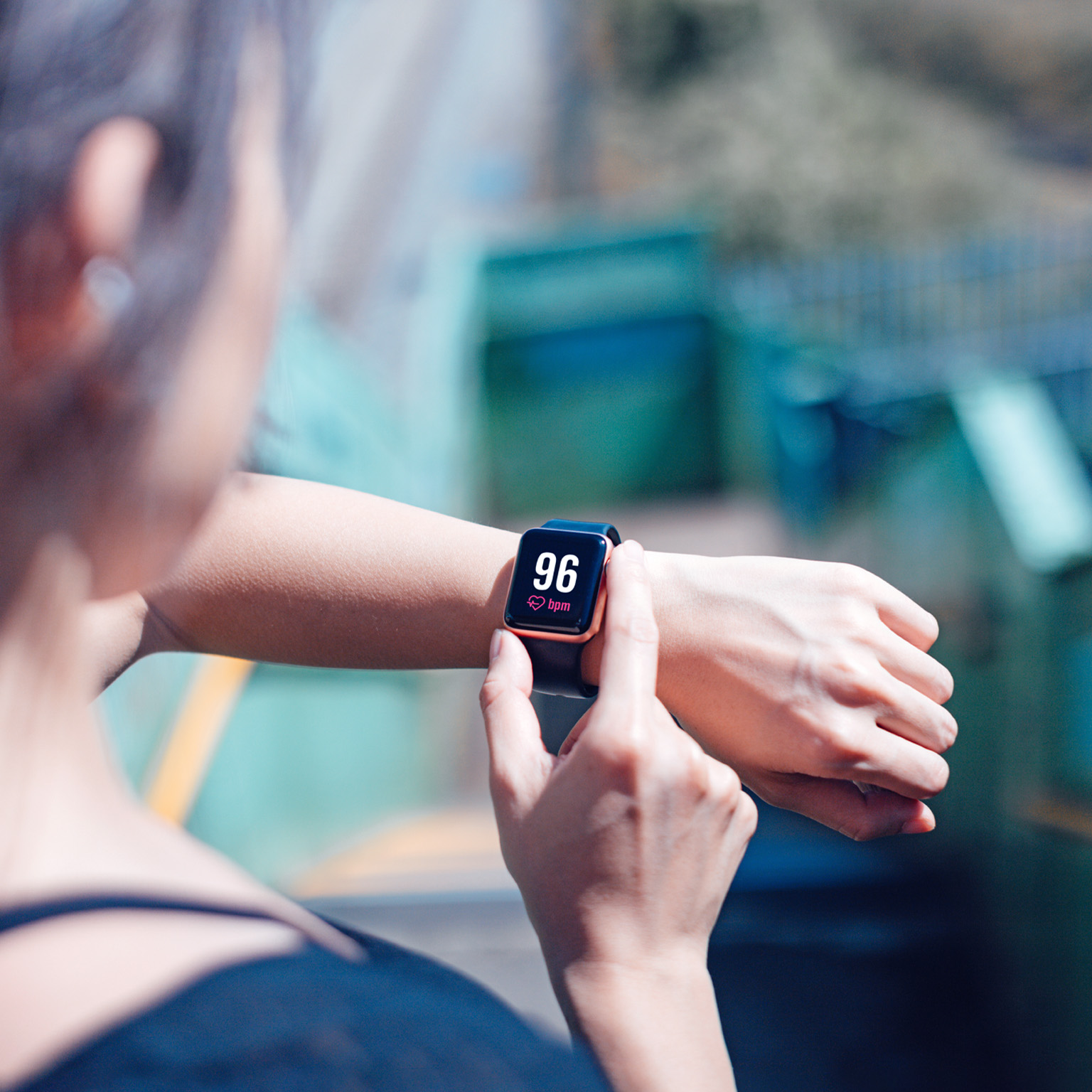A young woman checking her heart rate on a smart watch.