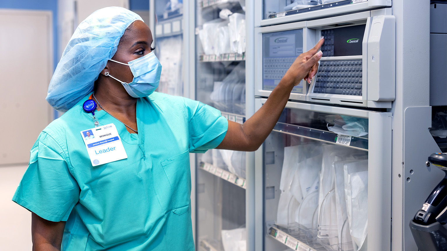 Healthcare worker in scrubs using automated medication system designed to streamline staff workflows and responsibilities