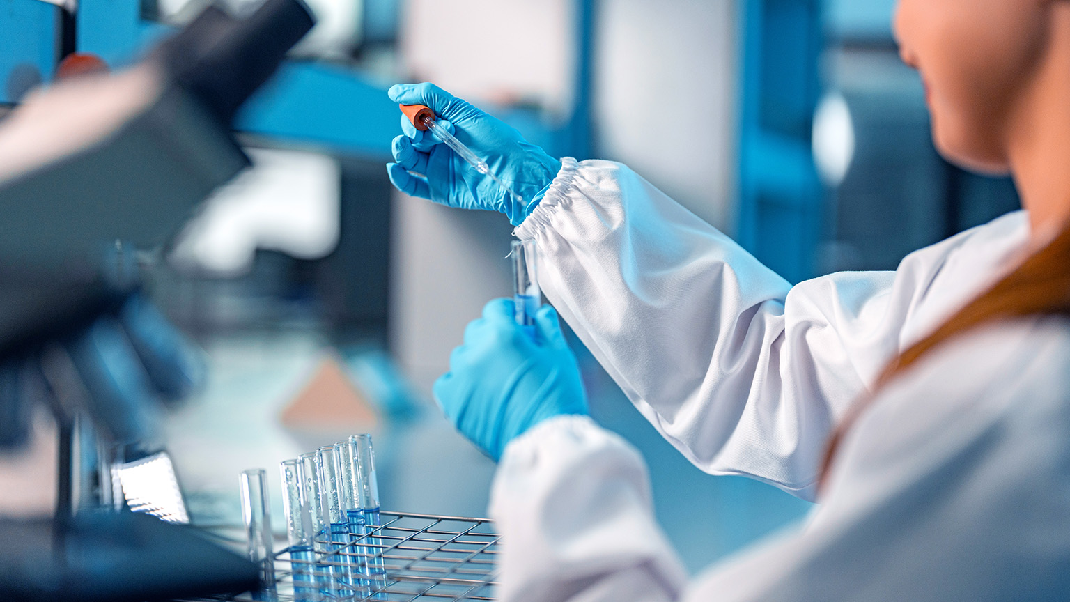 Laboratory researcher handling sample with syringe in clinical research lab