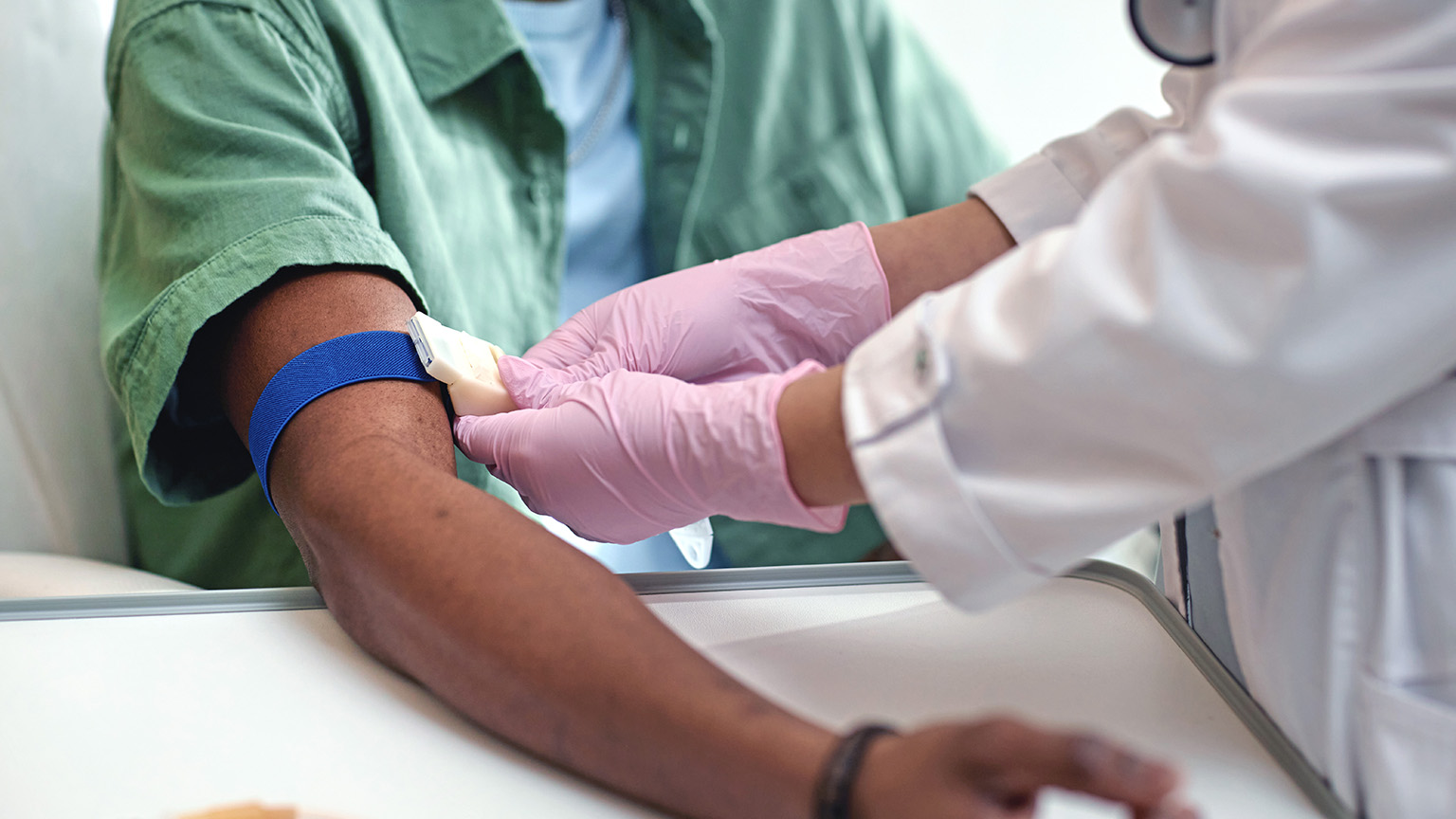 Healthcare professional drawing blood from patient's arm
