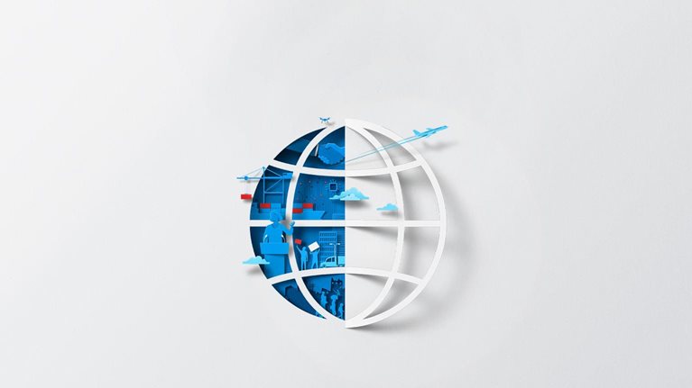 A white sheet of paper has been cut and folded in half, creating the silhouette of a globe. The open space left by the folded paper is filled with blue and red shapes, representing international trade, transportation, and geopolitics.