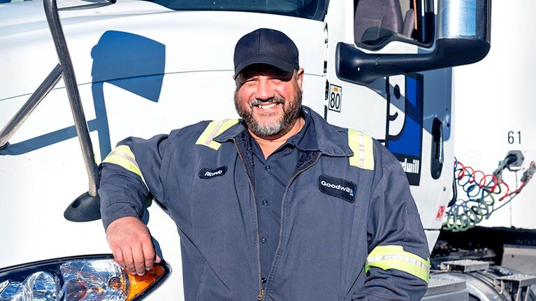 Goodwill employee standing by truck at work location