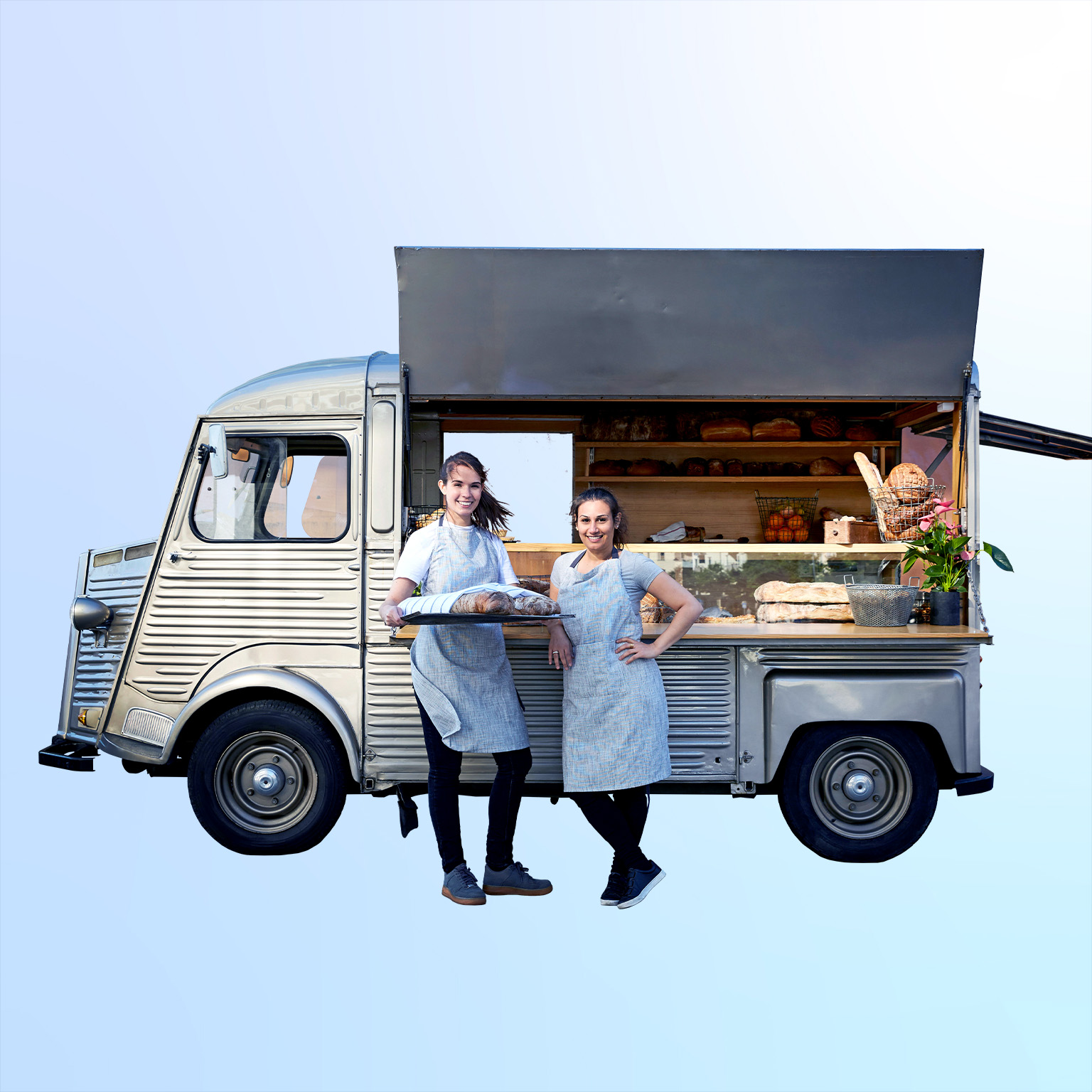 Image of confident women standing next to their vintage van that has been converted into a foot truck.