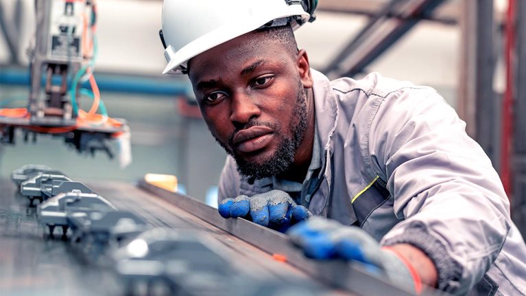 Quality engineer working in the automotive industry while checking the quality of components of automotive parts in the production line.